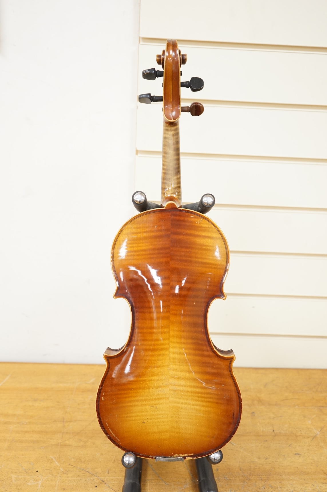 Five cased 20th century violins, including; a German violin, two Czech violins, a three-quarter size violin with a label for Bienfait, and a Romanian quarter size violin, all in cases or the remains of cases.
